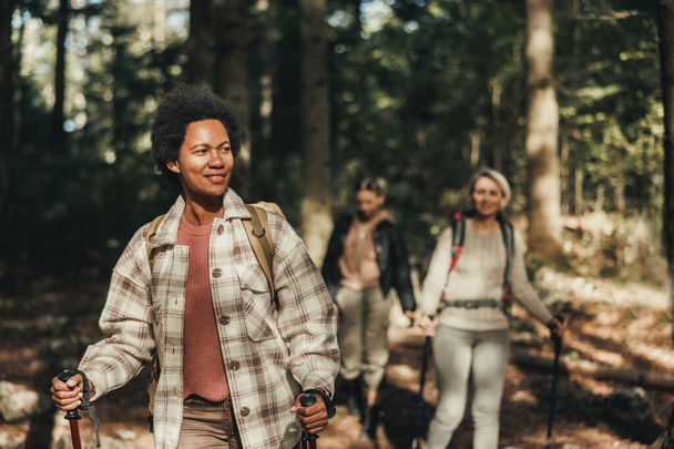 Madura mujer negra senderismo a través de las montañas con sus amigos. - Foto, Imagen