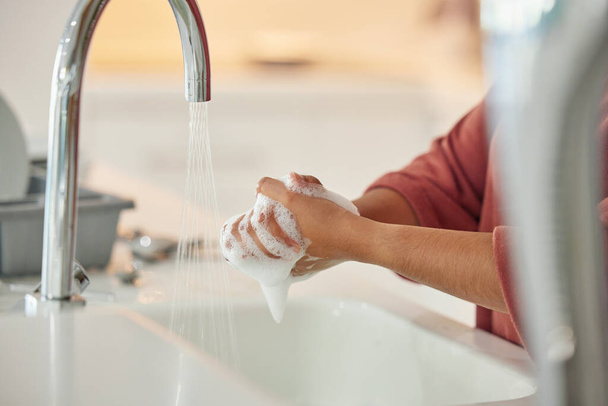 Lavarse las manos, la limpieza y la persona con higiene y agua para el bienestar en un grifo de cocina. Espuma de jabón, fregadero y hogar con prevención de bacterias y seguridad con desinfección con líquido antes de cocinar. - Foto, Imagen