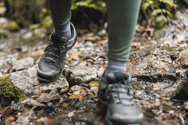 Cropped shot of an unrecognisable woman hiker crossing a stream while exploring in the woods. - Photo, Image