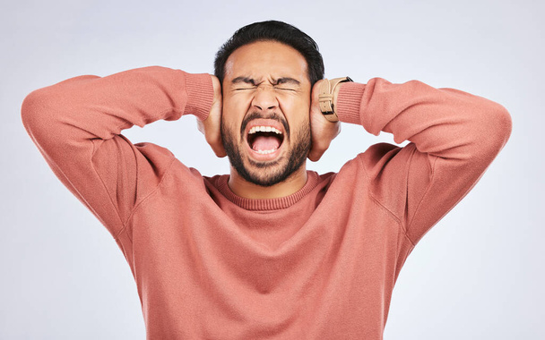 Výkřiky, úzkost a ruce na uši asijského muže ve studiu s bolestí hlavy, mlha mozku nebo frustrovaný na šedém pozadí. Hluk, stres a naštvaný člověk křičí na tinnitus, deprese nebo závratě. - Fotografie, Obrázek