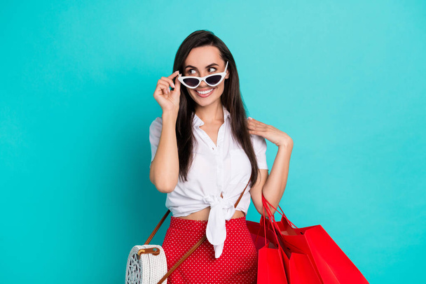 Photo of sweet thoughtful girl wear white tied shirt handbag dark glasses looking empty space holding bargains isolated teal color background. - Fotografie, Obrázek