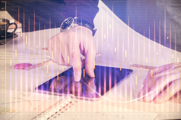 Double exposure of man's hands holding and using a digital device and forex graph drawing. Financial market concept. - Фото, зображення