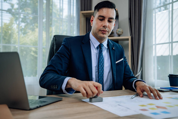 The determined business supervisor carefully analyzes the proposal contract before permitting. Once approved, the project is implemented with serious consideration, ensuring successful outcomes. - Photo, image
