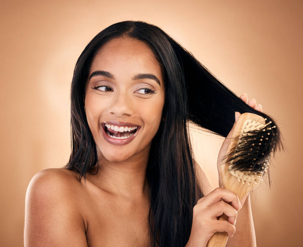 Hair care, brush and excited woman with beauty in studio isolated on a brown background. Salon, happy and model with wood grooming product for natural aesthetic, hairdresser or hairstyle for wellness. - Foto, Imagem