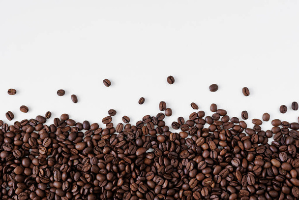 Zwarte koffiebonen op witte achtergrond met kopieerruimte - Foto, afbeelding