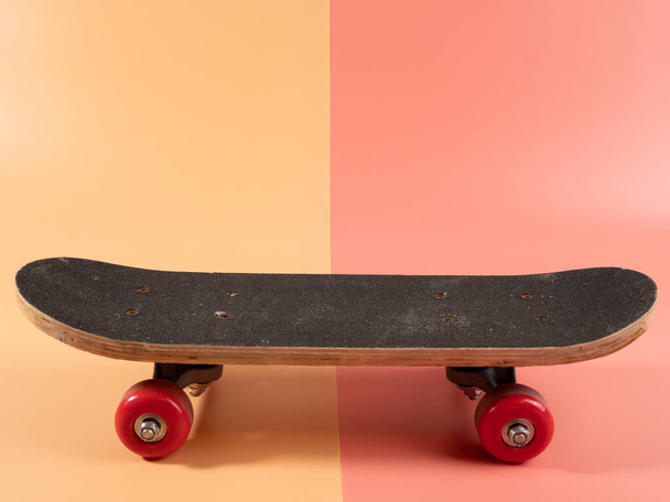 Skateboard on a pink and orange background. Skateboard close up. - Photo, Image