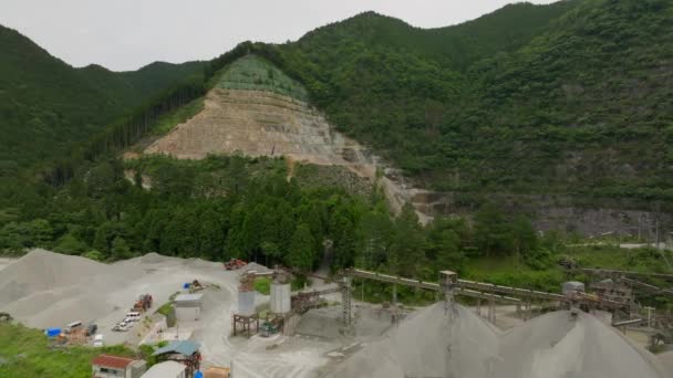 Movimento aéreo sobre pilhas de material em mina a céu aberto por floresta despojada na montanha. Imagens 4k de alta qualidade - Filmagem, Vídeo