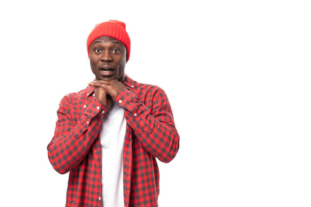 young african man in shirt in red plaid shirt over isolated white background. - Photo, Image