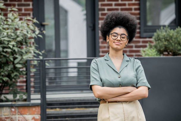 selbstbewusster afrikanisch-amerikanischer Immobilienmakler mit Brille, der im Freien in die Kamera blickt - Foto, Bild