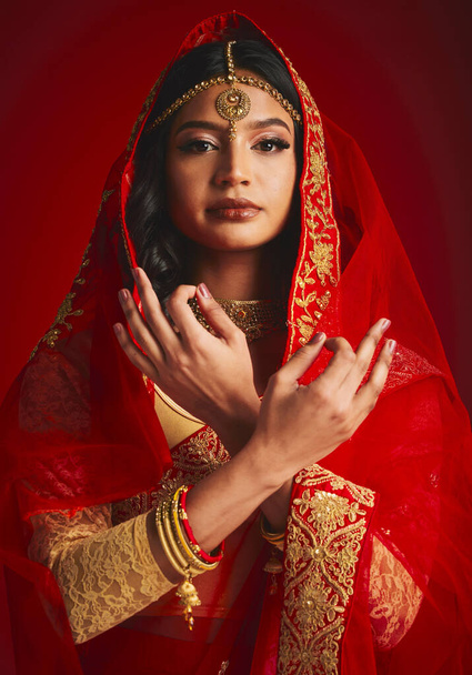 Moda, cultura y retrato de mujer india con letrero de mano en ropa tradicional, joyas y velo de sari. Religión, belleza y persona femenina sobre fondo rojo con accesorios, cosméticos y maquillaje. - Foto, Imagen