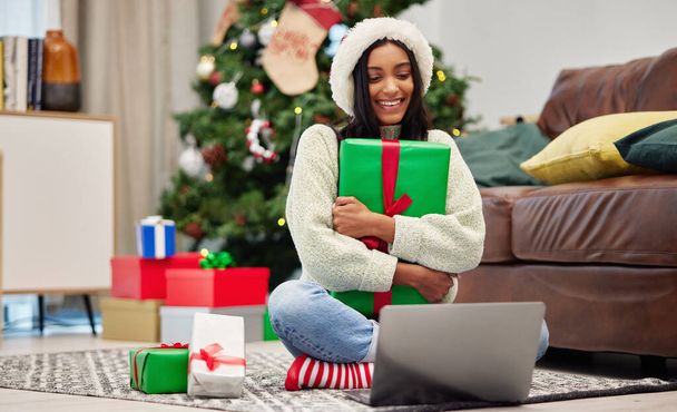 Woman, Christmas present and laptop, video call and celebrate holiday, happiness and communication. Virtual conversation, contact on pc and female person at home with gift giving, package and smile. - Photo, image