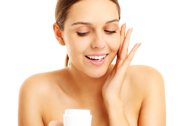 Pretty woman applying cream on face - Photo, Image
