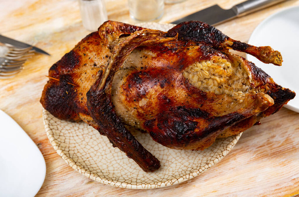Rustic style whole roasted goose stuffed with barley served on plate - Фото, изображение