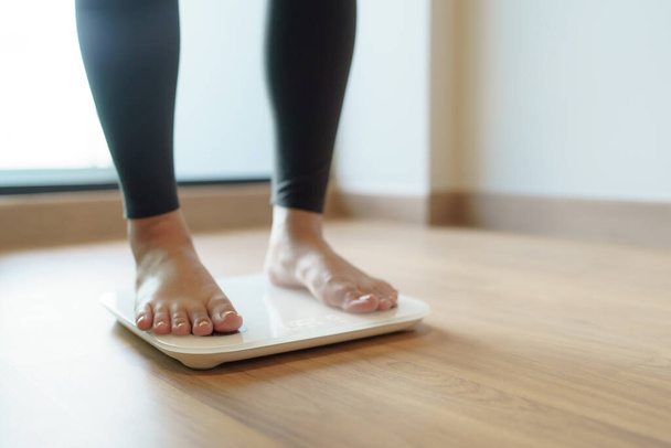 Schudnąć. Dieta tłuszczowa i skala stóp stojących na wadze elektronicznej do kontroli masy ciała. Przyrząd pomiarowy w kilogramach do żywienia - Zdjęcie, obraz