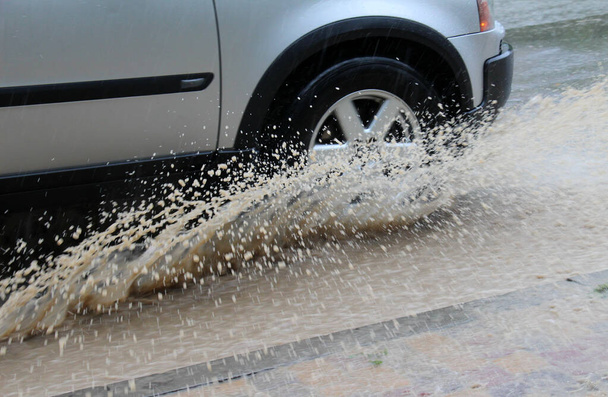 Автомобільні колеса у воді під час сильного дощу - Фото, зображення