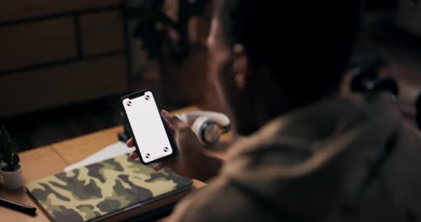 Tech Enthousiaste man, gezien vanaf de achterkant, heeft een mobiele telefoon en laptop met witte schermen, suggereert dat hij een tech liefhebber die geniet van het verkennen van de nieuwste digitale trends en verbonden blijven. - Video