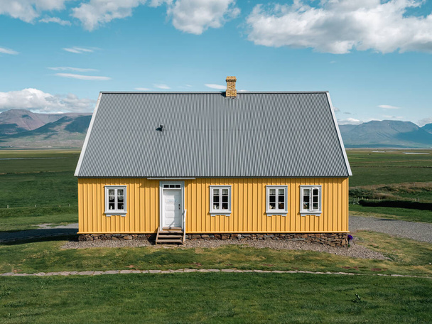 Afbeelding van Traditional turf covered house in Glaumbaer, northwestern Iceland. Landbouwvelden met paarden en besneeuwde bergen op de achtergrond - Foto, afbeelding