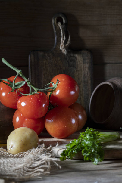 Red tomatoes on a rustic table - Foto, afbeelding