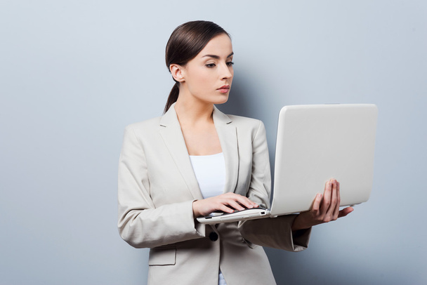 Confident businesswoman holding laptop - Foto, afbeelding