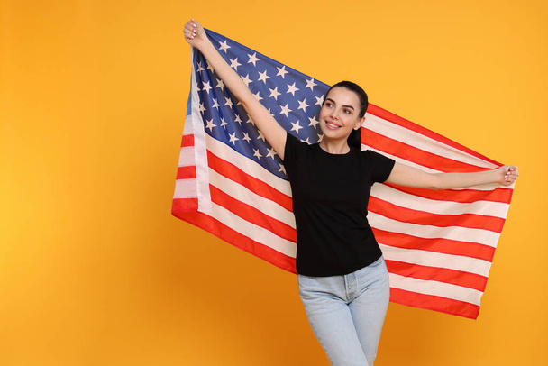 4th of July - Independence Day of USA. Happy woman with American flag on yellow background, space for text - Фото, зображення