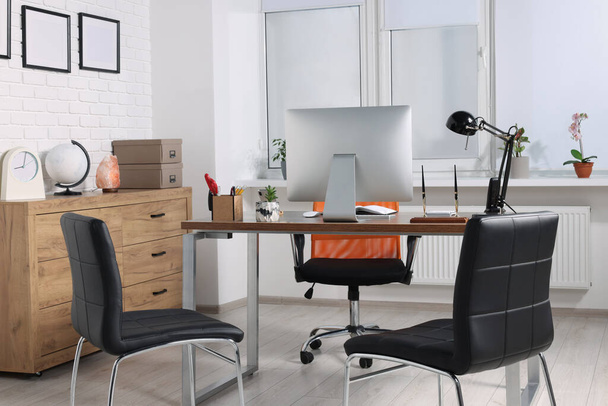 Stylish director's workplace with comfortable desk, computer and chairs for visitors in office. Interior design - Photo, Image