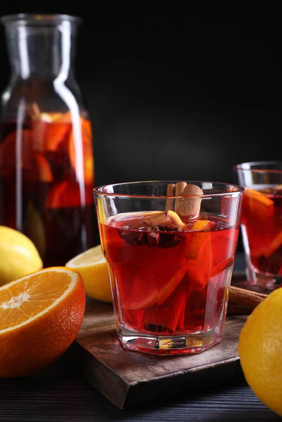 Aromatic punch drink and ingredients on black table - Photo, image