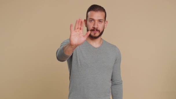 Lebanese man say No hold palm folded crossed hands in stop gesture, warning of finish, prohibited access, declining communication body language, danger. Young guy on beige background. People lifestyle - Footage, Video