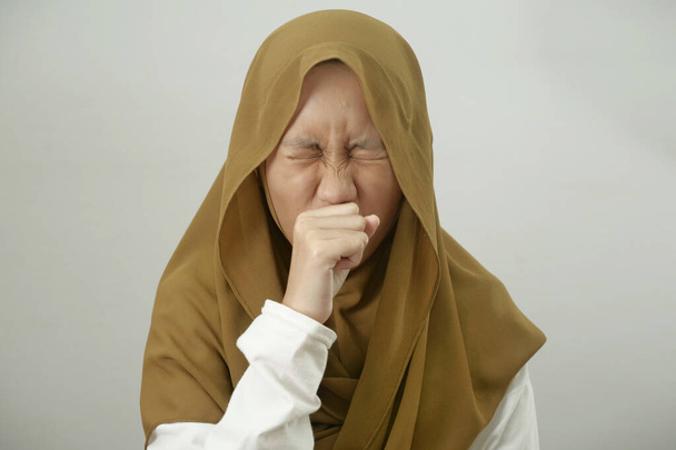Asian muslim teenage girl wearing hijab cough, respiratory health problem, medical disease health care concept - Photo, image