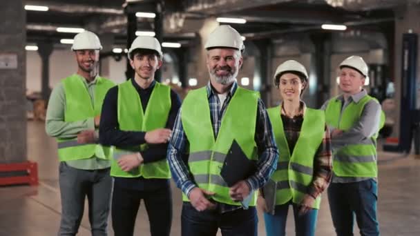A Group of Warehouse Workers Stands in a Large Distribution Center with their Arms Crossed. Portrait of the Workers. People Looking at the Camera with Smile. Logistic. Distribution - Footage, Video