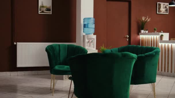 Leere luxuriöse Reise-Lounge mit Check-in-Rezeption. Dolly in Aufnahme des stilvollen Hotelfoyers Interieur mit noblen grünen Möbeln bereit, um Besucher willkommen zu heißen. - Filmmaterial, Video