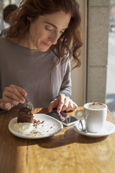 女性のチョコレート ケーキと電話 - 写真・画像
