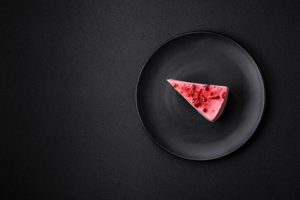 Delicious sweet dessert cheesecake with raspberry and pistachio flavor on textured concrete background - Foto, afbeelding