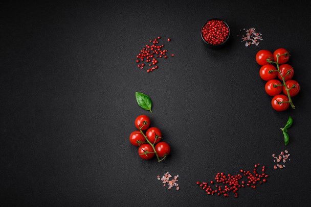 Ingredientes para cozinhar tomates cereja, sal, especiarias e ervas em um fundo de concreto escuro - Foto, Imagem