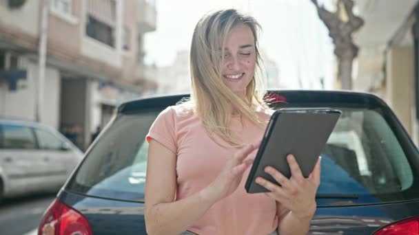 Giovane donna bionda utilizzando smartphone in piedi in auto in strada - Filmati, video