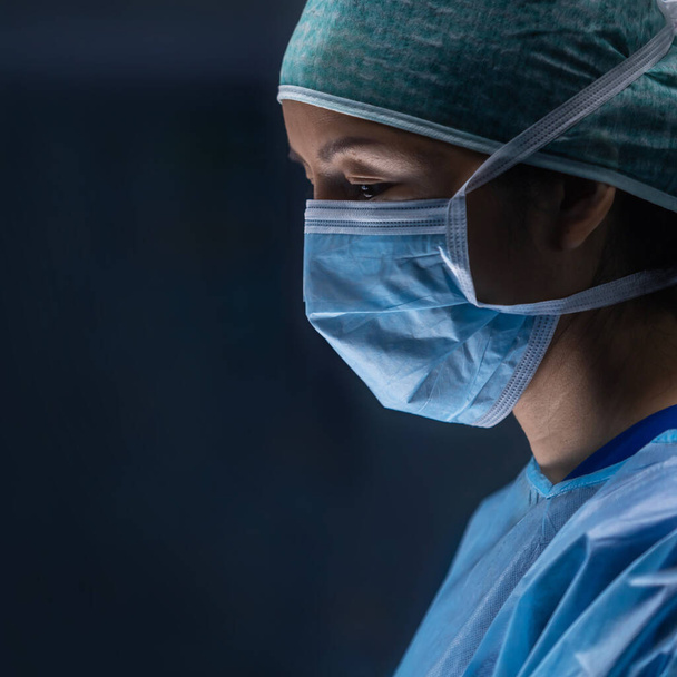 Diverse team of professional medical doctors performs a surgical operation in a modern operating room using high-tech equipment and technology. Surgeons are working to save the patient in the hospital - Photo, Image
