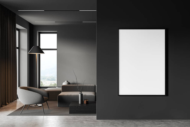 Interior of stylish living room with gray walls, concrete floor, comfortable gray sofa and armchair, dark wooden coffee table and vertical mock up poster frame in foreground. 3d rendering - Zdjęcie, obraz