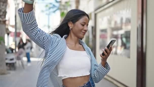 Mujer afroamericana escuchando música por teléfono inteligente bailando en la calle - Metraje, vídeo