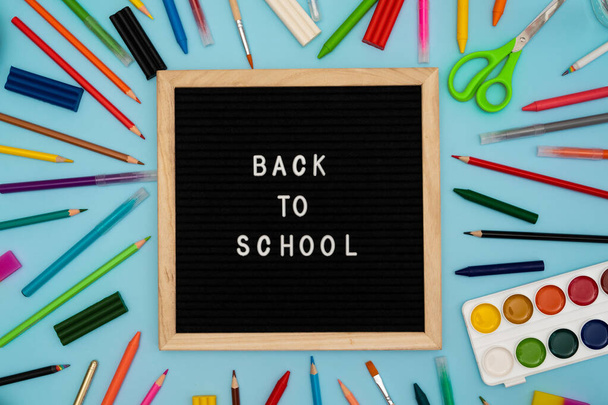Text: Back to school soon on a wooden letter board. buying stationery, flatlay, bright background. Autumn school fees. - Photo, Image