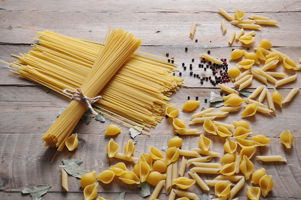 料理のコンセプトです。調理のイタリア パスタ: 春雨、木製の背景により糸のスパゲッティ - 写真・画像