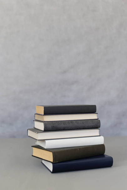stack of books on the wooden desk. - Фото, изображение