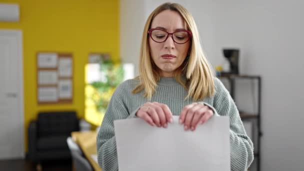 Jeune femme blonde femme d'affaires rupture de document au bureau - Séquence, vidéo