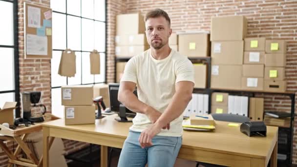Young man ecommerce business worker standing with arms crossed gesture at office - Footage, Video