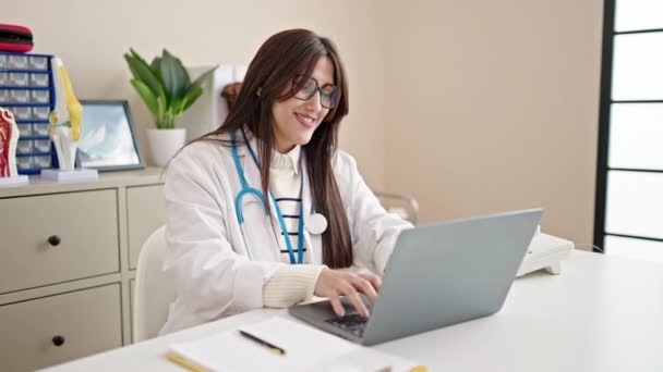 Fiatal gyönyörű spanyol nő orvos segítségével laptop dolgozik a klinikán - Felvétel, videó