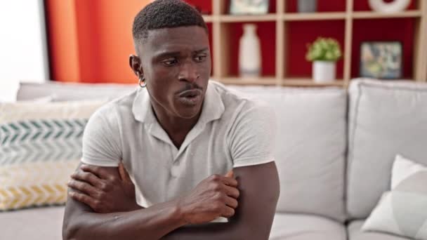 Африканський американець посміхається впевнено сидить на дивані, розмовляючи вдома - Кадри, відео