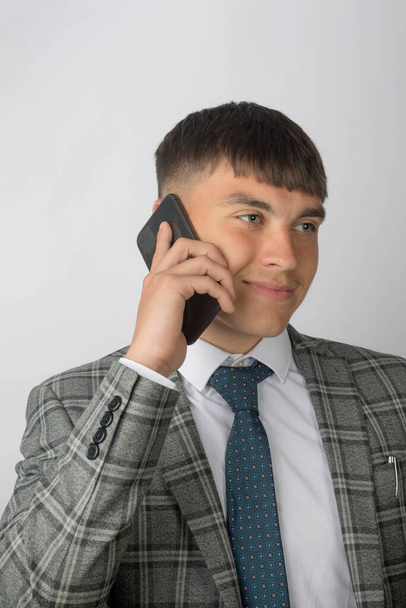 Young entrepreneur wearing a suit and tie making a phone call - Fotó, kép