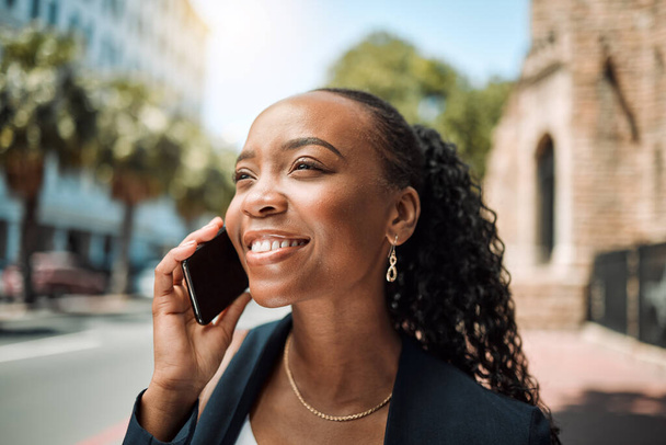 Happy black woman, phone call and city in travel, conversation or communication outdoors. African female person smile for business discussion, networking or work trip on smartphone in an urban street. - Фото, зображення