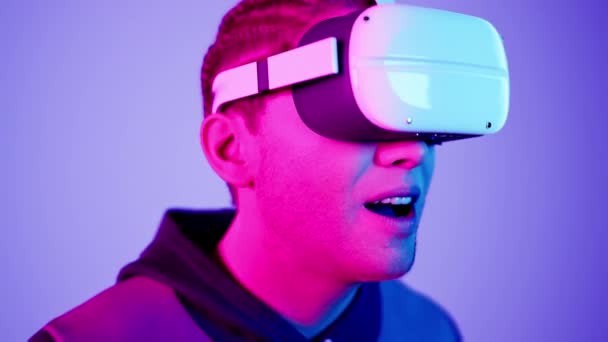 tecnología, juego en línea, entretenimiento, mundo virtual en simulación 3D. millennial hombre en gafas vr juega en neón, plano de estudio, 3d render. - Metraje, vídeo