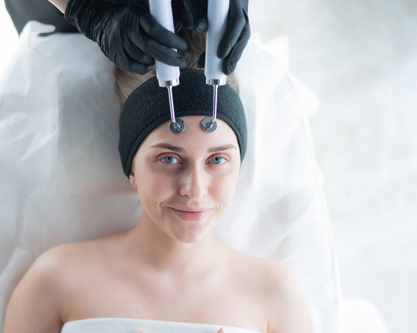 Young caucasian woman on microcurrent therapy procedure. Beauticians office - Fotografie, Obrázek