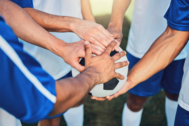 Football, hands together and teamwork, support and sports for training at stadium. Collaboration, huddle and soccer players with motivation for exercise target, workout goal or success in competition. - Photo, Image