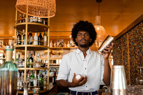 young latin bartender with a shaker - Fotó, kép